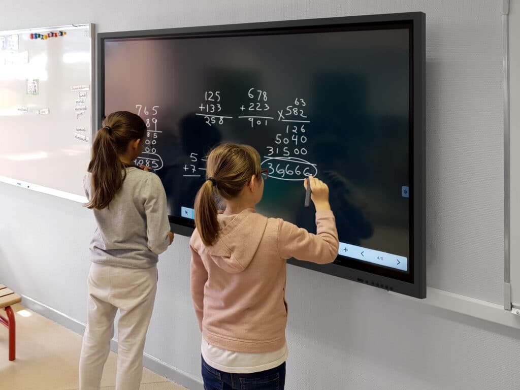 Eleves écrivant a l'écran interactif